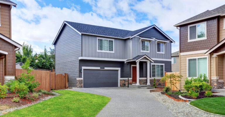 Two-story gray house with attached two-car garage and landscaped driveway.